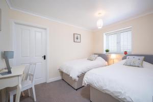 a bedroom with two beds and a desk and a desk at Luxury, Spacious Cottage in the Black Mountains in Hereford