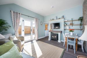 een woonkamer met een tafel en een open haard bij Luxury, Spacious Cottage in the Black Mountains in Hereford