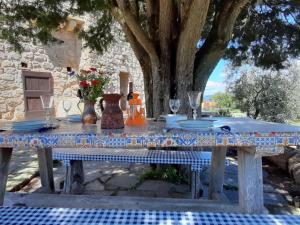 een tafel met borden en wijnglazen erop bij Apartment Mimosa - Borgo la Civitella by Interhome in Roccastrada