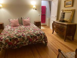 Schlafzimmer mit einem Bett, einer Kommode und einem Spiegel in der Unterkunft Le brûlon in Bourg-le-Comte