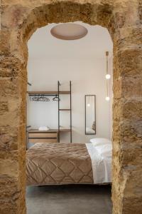 a bedroom with a bed in a stone wall at Mag 179 Bed & Spa in Palermo