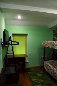 Pokój z zieloną ścianą i łóżkami piętrowymi w obiekcie motel Pid Strihoyu w mieście Krzemieńczuk