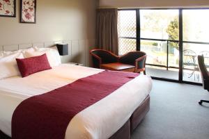 ein Hotelzimmer mit einem großen Bett und einem Fenster in der Unterkunft Club Mulwala Resort in Mulwala