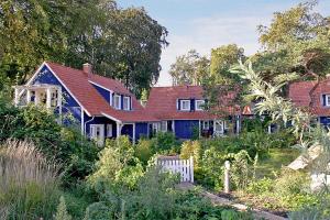 ein blaues Haus mit rotem Dach in der Unterkunft SEETELHOTEL Nautic Usedom Dünenhäuser in Ückeritz