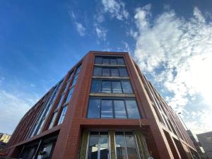 un edificio alto de ladrillo rojo con un cielo en el fondo en 1 Bedroom Apartments in Digbeth, en Birmingham