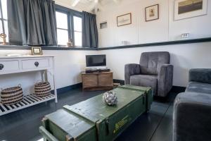 ein Wohnzimmer mit einem Tisch, 2 Stühlen und einem TV in der Unterkunft Fortwachterswoning in Huisduinen