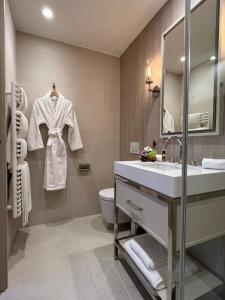 bagno con lavandino, servizi igienici e specchio di Black Door a Parigi