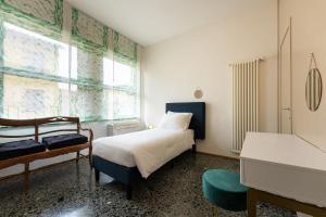 a bedroom with a bed and a window and a piano at Por Santa Maria Apartment in Florence