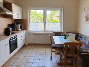 een keuken met een tafel en een groot raam bij Ferienwohnung Christina in Hinterweiler