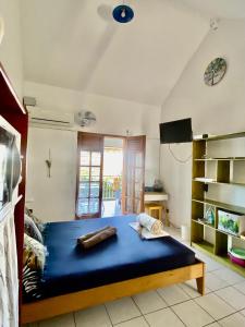 a bedroom with a blue bed and a television at SERENITY piscine au sel in La Trinité