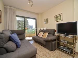 ein Wohnzimmer mit Sofas und einem Flachbildfernseher in der Unterkunft Super Beach 6H in Platja  d'Aro