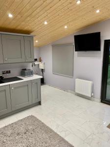 a large kitchen with a flat screen tv on the wall at Cullentra Lodge in Cushendall