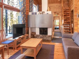 a living room with a fireplace in a log cabin at Holiday Home Villa rukaherttua by Interhome in Ruka