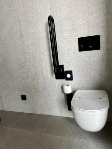 a white toilet in a bathroom with a phone on the wall at HasHotel in Hasselt