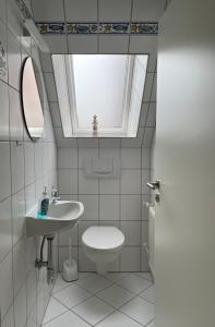 Un baño con inodoro, lavabo y ventana. en Ferienwohnung LaMer, en Borkum 8 fotos más