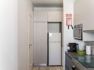 a white kitchen with a refrigerator in the corner at Apartment Casa Avó Lucy by Interhome in Portimão