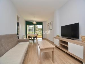 ein Wohnzimmer mit einem Sofa und einem Flachbild-TV in der Unterkunft Super Beach 10H in Platja  d'Aro