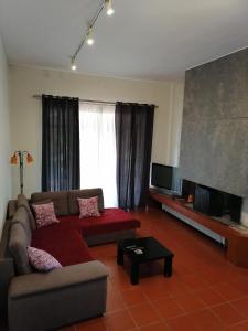 sala de estar con sofá y TV de pantalla plana en Ευχάριστη βίλα στη Χαλκίδα στην περιοχή ''Αλυκές'' en Chalkida