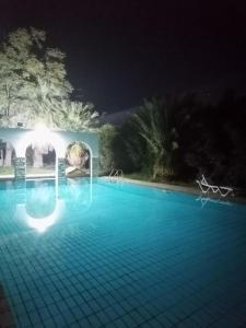 a swimming pool at night with the lights on at Ευχάριστη βίλα στη Χαλκίδα στην περιοχή ''Αλυκές'' in Chalkida