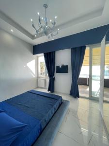 a bedroom with a blue bed and a chandelier at Residenza 4 Colonne CONTEMPORANEA in Santa Maria al Bagno