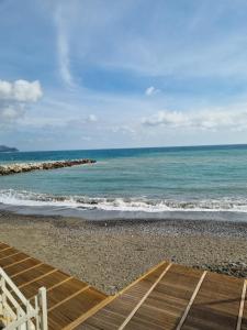 a view of the ocean from a beach with a wooden deck at Albergo Stella Di Mare in Lavagna