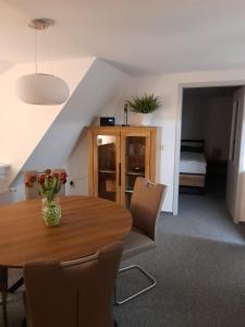 een eetkamer met een houten tafel en stoelen bij Himmel & Hölle, Heiligegeiststrasse 22 in Quedlinburg