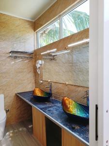 a bathroom with two sinks and a window at Island Life Maldives Retreat & Spa in Magoodhoo