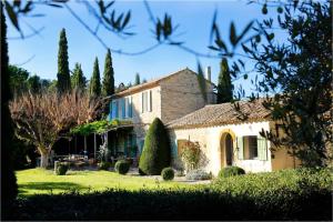 a large stone house with trees in the yard at Villa charmante Beaumes-de-Venise in Beaumes-de-Venise