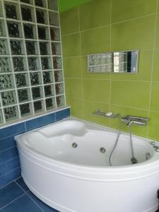 a bath tub in a bathroom with green tiles at Ευχάριστη βίλα στη Χαλκίδα στην περιοχή ''Αλυκές'' in Chalkida