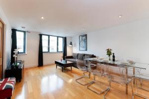 uma sala de estar com uma mesa e um sofá em The Great London Apartments em Londres
