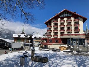a large building with snow in front of it at Apartment Eiger Residence Apt-A-425 by Interhome in Wengen