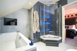a bathroom with a tub and a shower stall at The Cranleigh Boutique in Bowness-on-Windermere