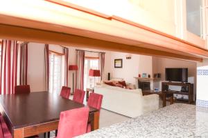 a dining room and living room with a table and chairs at Casa Querida in Óbidos
