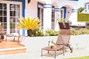 a house with two chairs on a patio at Casa Querida in Óbidos