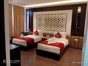 a hotel room with two beds with red sheets at Ramada by Wyndham Gangtok Hotel & Casino Golden in Gangtok