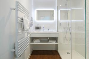 a white bathroom with a sink and a shower at Westotel Tours Val de Loire in La Ville-aux-Dames