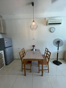 een tafel en stoelen in een keuken met een klok aan de muur bij Heart of Petaling Jaya near LRT Line 5 (8) in Petaling Jaya