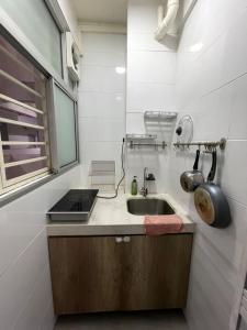 een kleine keuken met een wastafel en een raam bij Heart of Petaling Jaya near LRT Line 5 (8) in Petaling Jaya