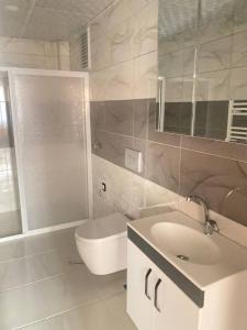 uma casa de banho branca com um WC e um lavatório em Elegance Residence em Kayseri