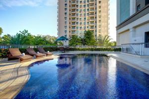 a large swimming pool with chairs and a building at Quality Rio de Janeiro - Barra da Tijuca in Rio de Janeiro