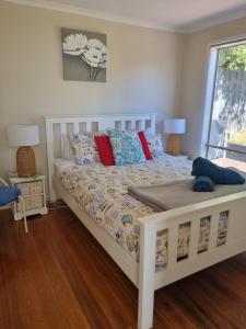 1 cama blanca en un dormitorio con ventana en Vitamin Sea, en Rosebud