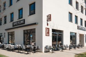 a restaurant with tables and chairs outside of a building at Coffee Fellows Hotel München-Freiham in Munich