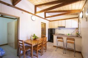 a kitchen with a wooden table and chairs in it at Camping Linus in Marina di Massa
