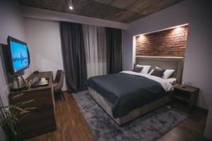 a hotel room with a bed and a television at City Centar House in Niš
