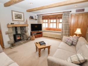 a living room with a couch and a fireplace at Greenfield Cottage in Oakworth