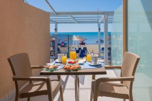 uma mesa com comida e vista para a praia em Sea Diamond Suites em Laganas