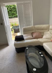 a living room with a couch and a glass table at Captivating 2-Bed House in Wolverhampton in Wolverhampton