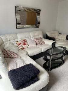 uma sala de estar com um sofá branco e uma mesa em Captivating 2-Bed House in Wolverhampton em Wolverhampton