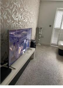 uma sala de estar com uma grande televisão de ecrã plano em Captivating 2-Bed House in Wolverhampton em Wolverhampton