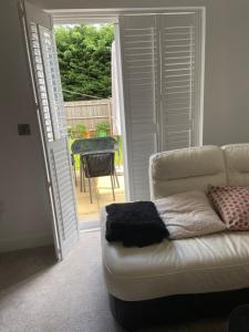 a living room with a couch and an open door at Captivating 2-Bed House in Wolverhampton in Wolverhampton